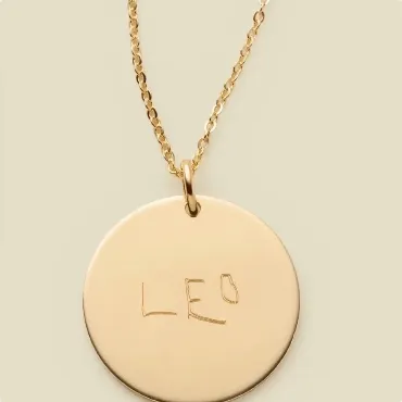 Handwritten Leo gold disc necklace.