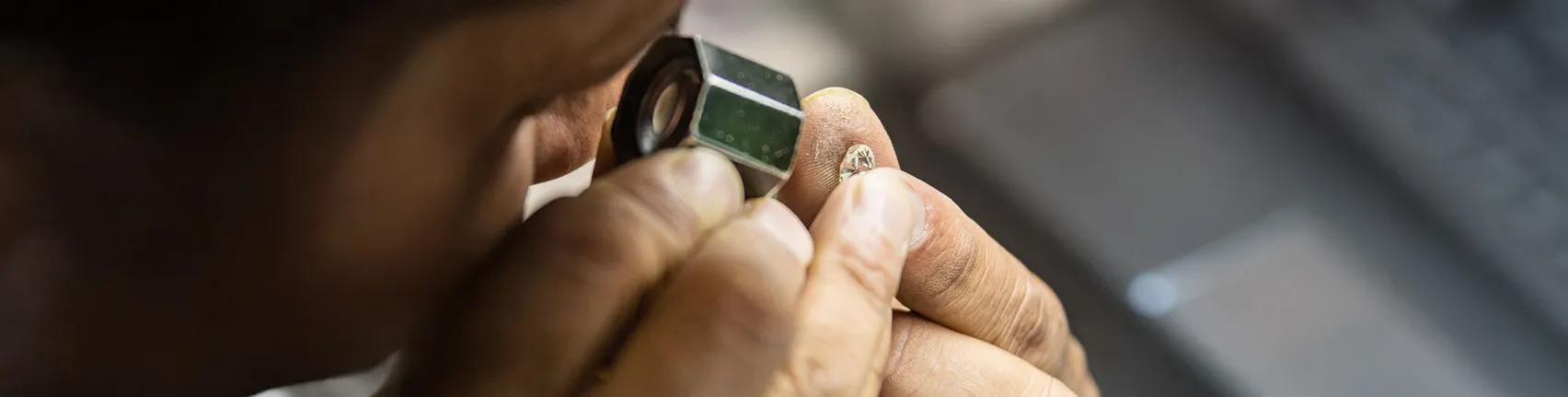 Jeweler inspecting diamond with loupe during appraisal process