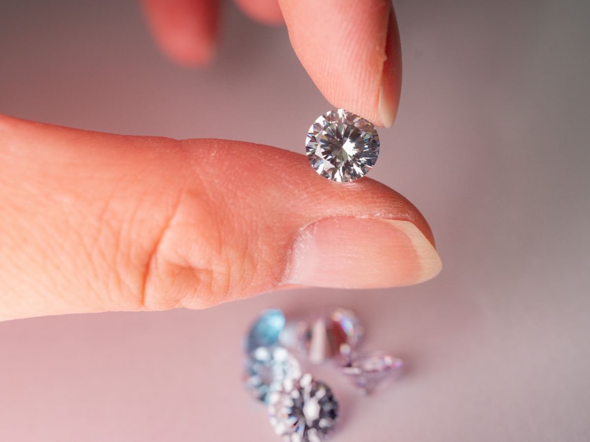 Close-up of a diamond held by fingers