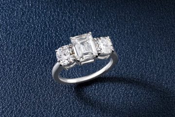 White gold ring with emerald-cut center and two round diamonds
