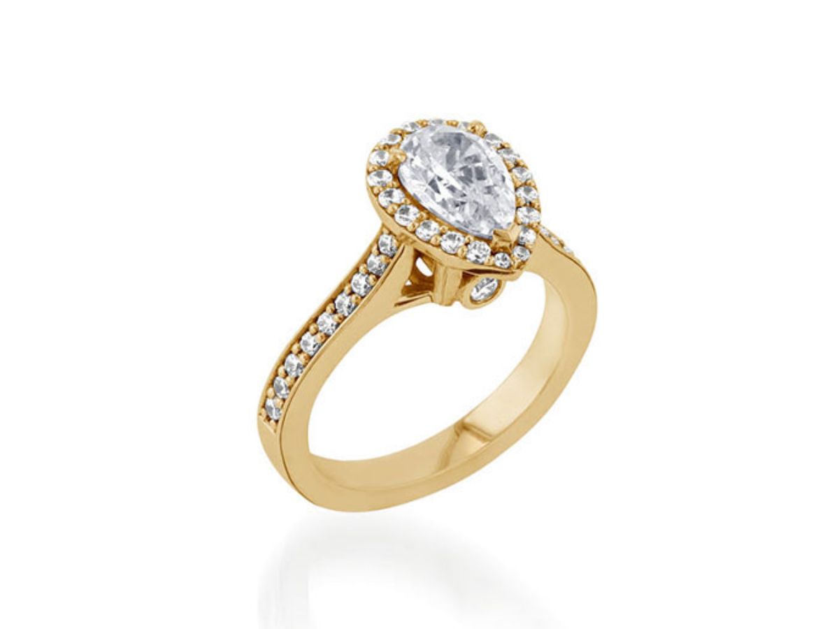 Yellow gold engagement ring with pear-shaped diamond and halo setting