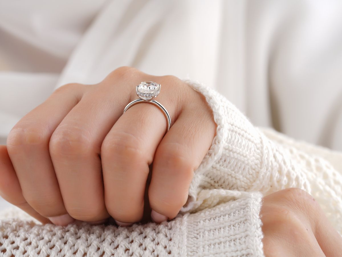 Woman's hand wearing solitaire diamond ring
