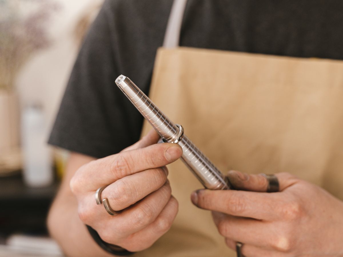 Jeweler measuring ring size with sizer tool in workshop