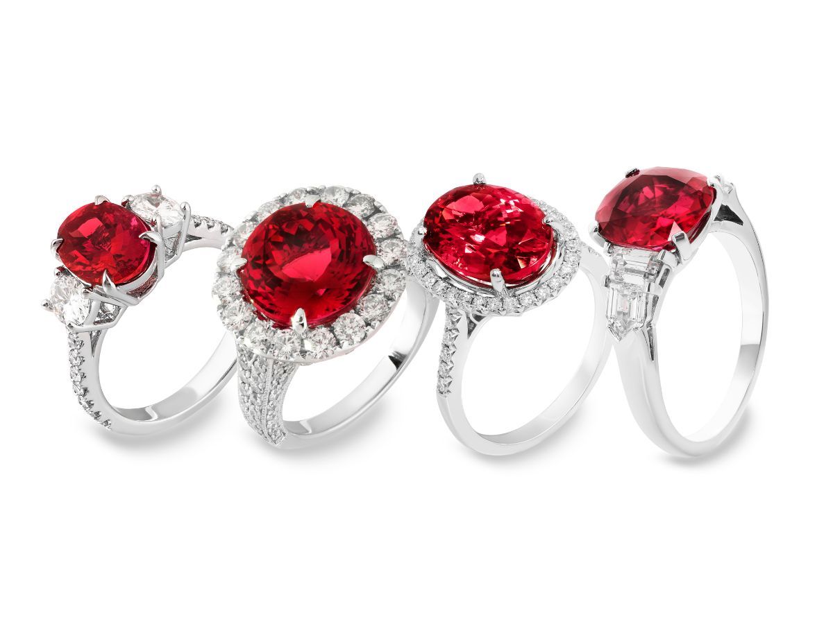 Set of four ruby rings with diamond halos in silver bands