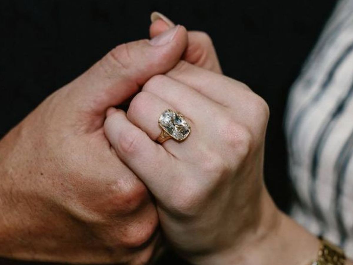 Close-up of hands showing vintage-style gold band with diamond ring