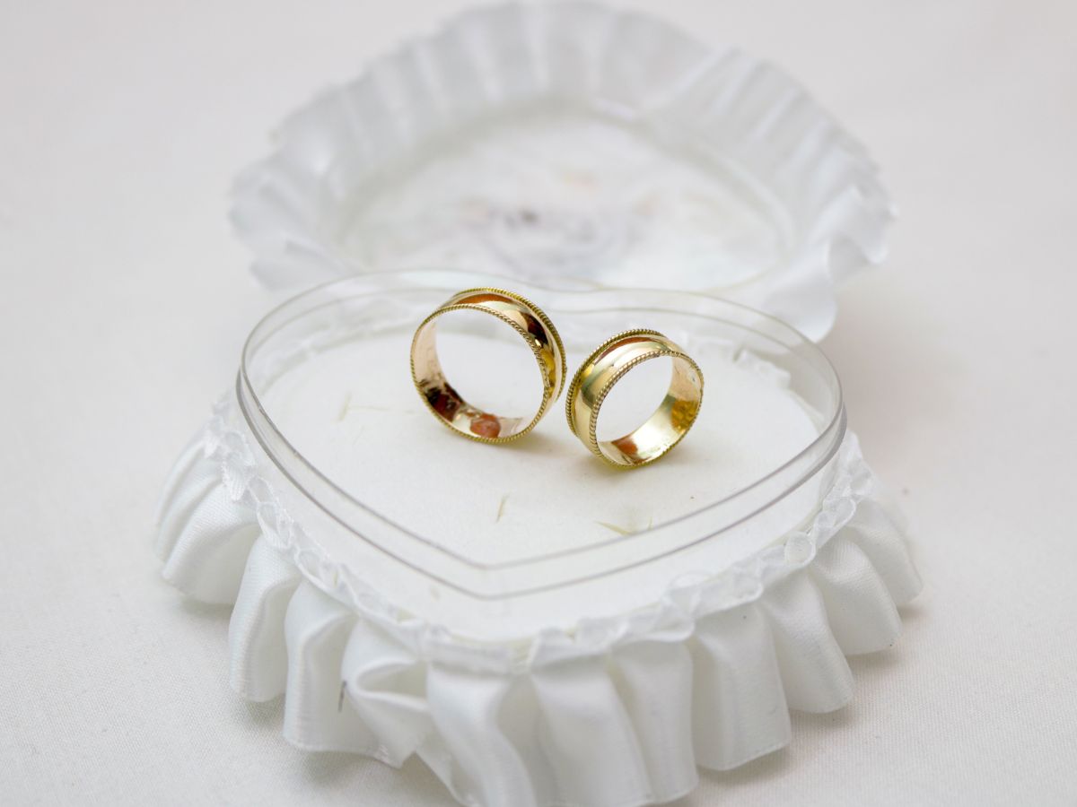 Two gold wedding rings in heart-shaped satin ring box
