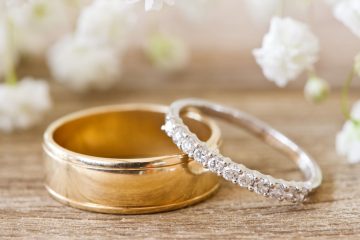 Gold and diamond wedding rings on rustic wooden table