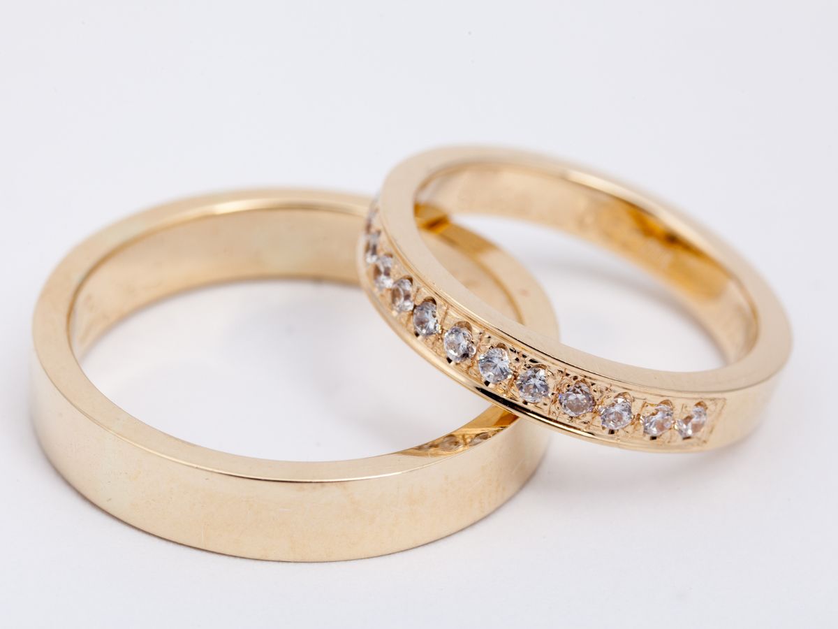 Gold wedding bands with diamonds on white background