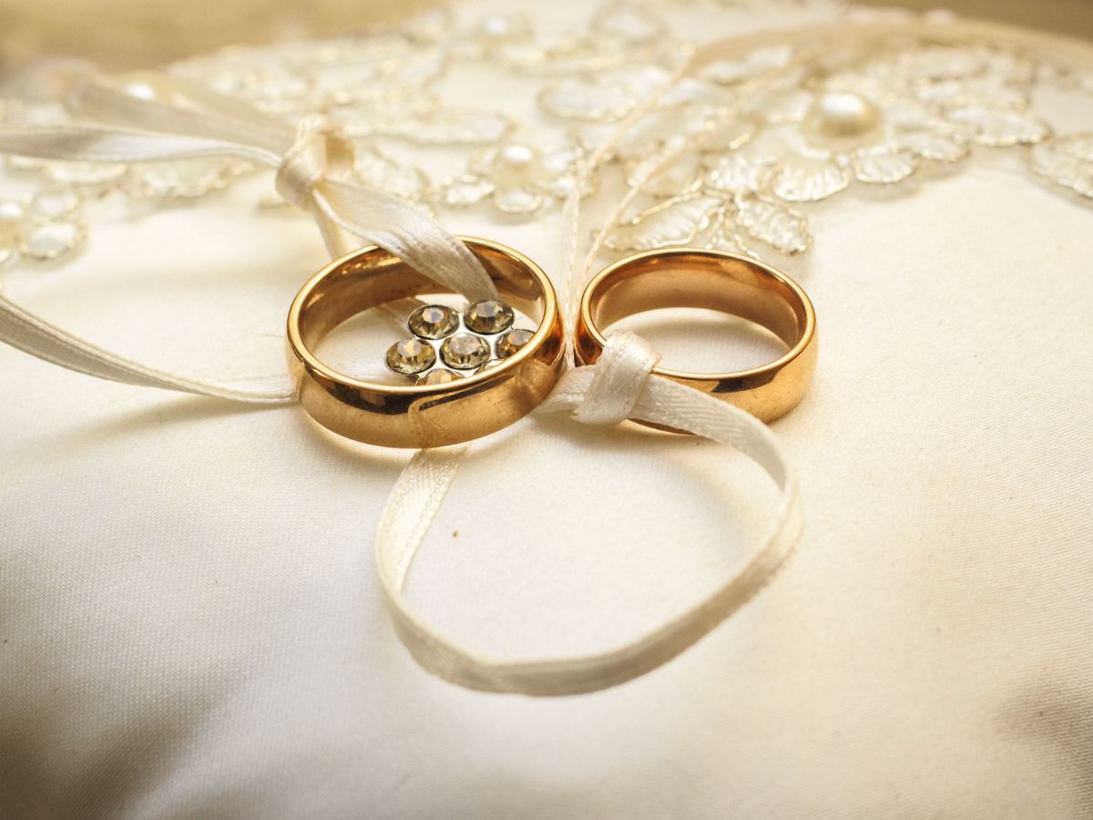 Two gold wedding bands tied with ivory satin ribbon