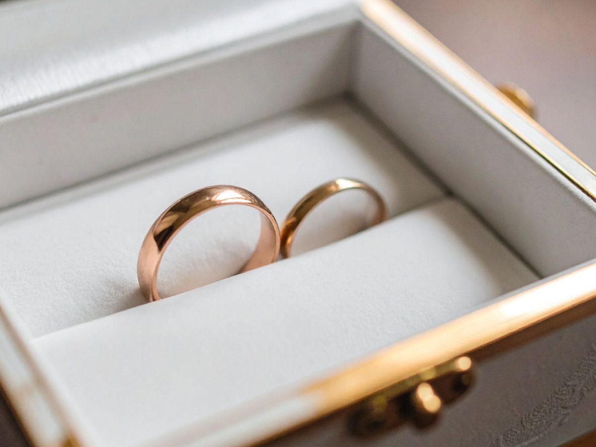 Gold wedding ring set in white cushioned ring box