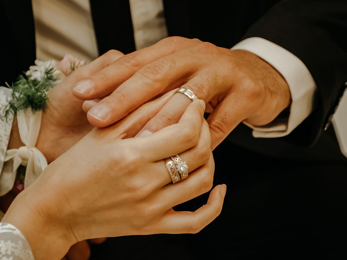 A close-up of a couple's hands wearing wedding rings