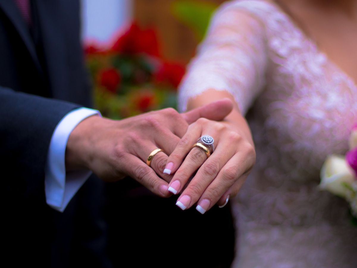 Closeup of married couple showing hands with wedding bands
