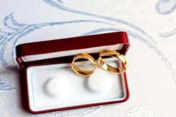 Close-up of Gold wedding bands inside red velvet jewelry box