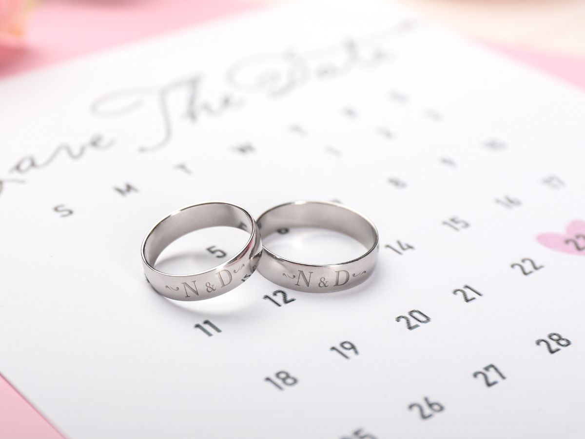 Engraved silver wedding bands on calendar save the date