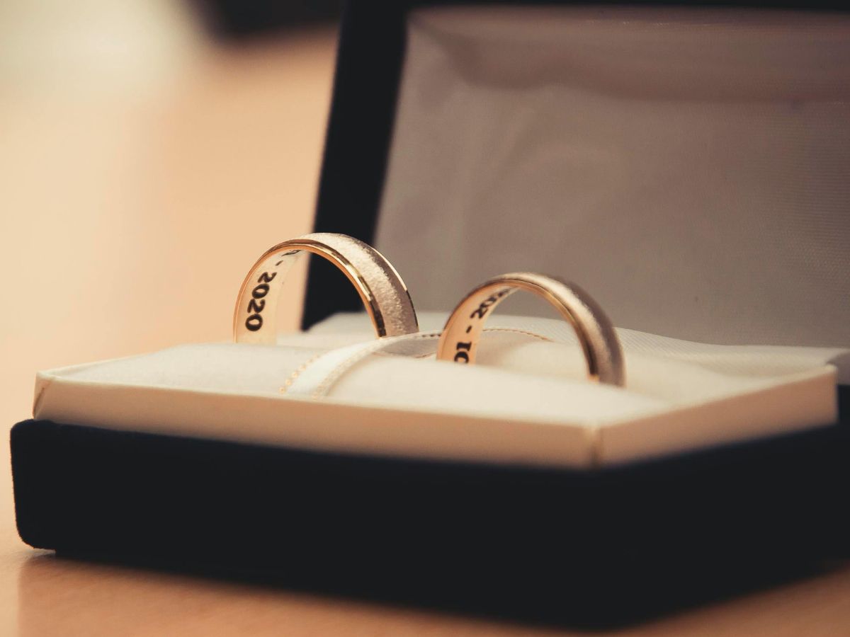 Gold wedding rings engraved with wedding date inside jewelry box