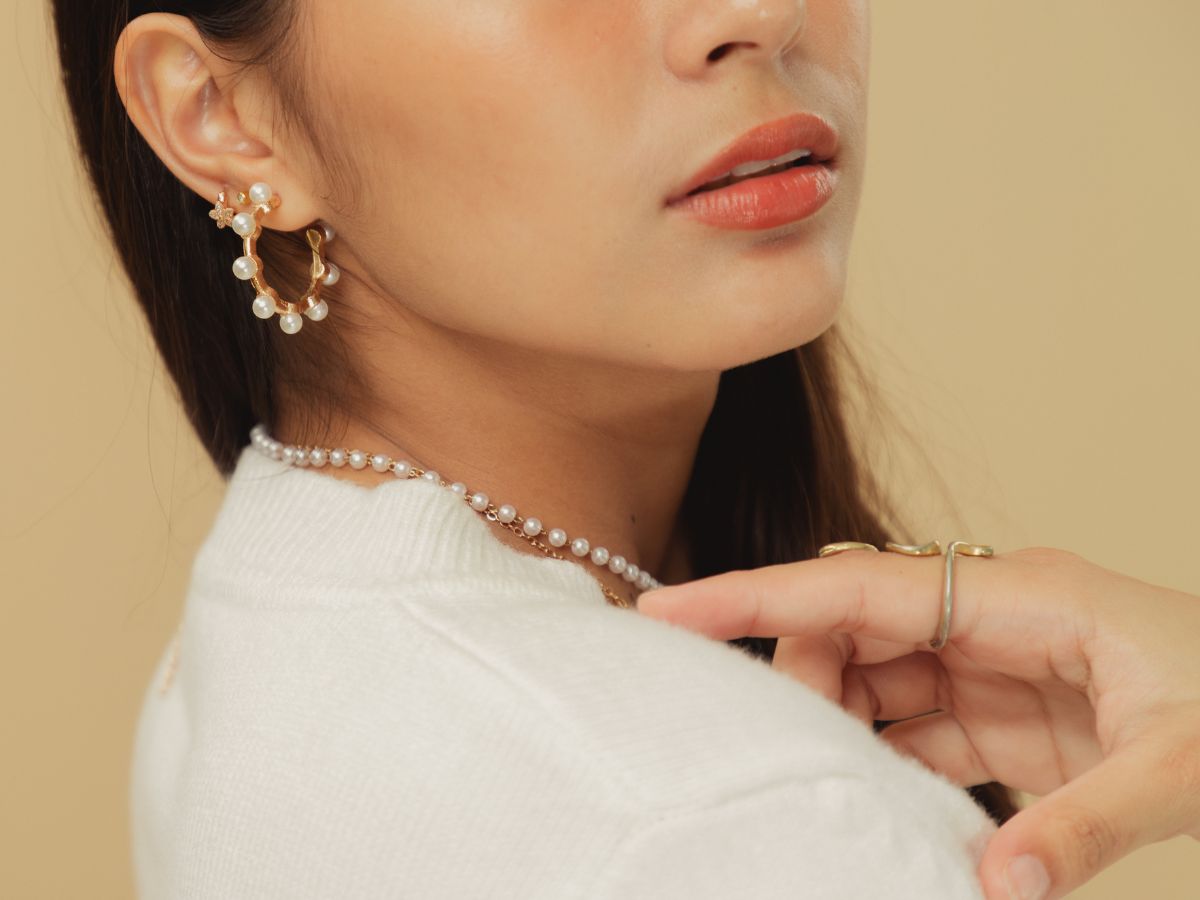 Close-up of model with pearl jewelry and minimal gold accessories