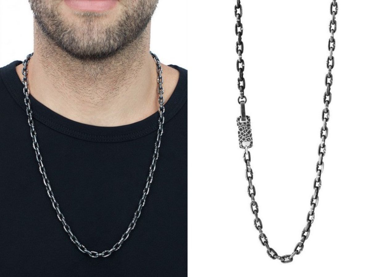 Close-up of man wearing black shirt with silver link chain necklace