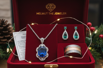An open red velvet jewelry box featuring a sapphire pendant, emerald earrings, and a two-tone ring, surrounded by holiday decorations.