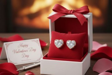 Valentine's Day gift box with heart-shaped diamond earrings, surrounded by rose petals and a card.