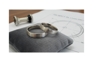 Matching brushed metal wedding bands on cushion