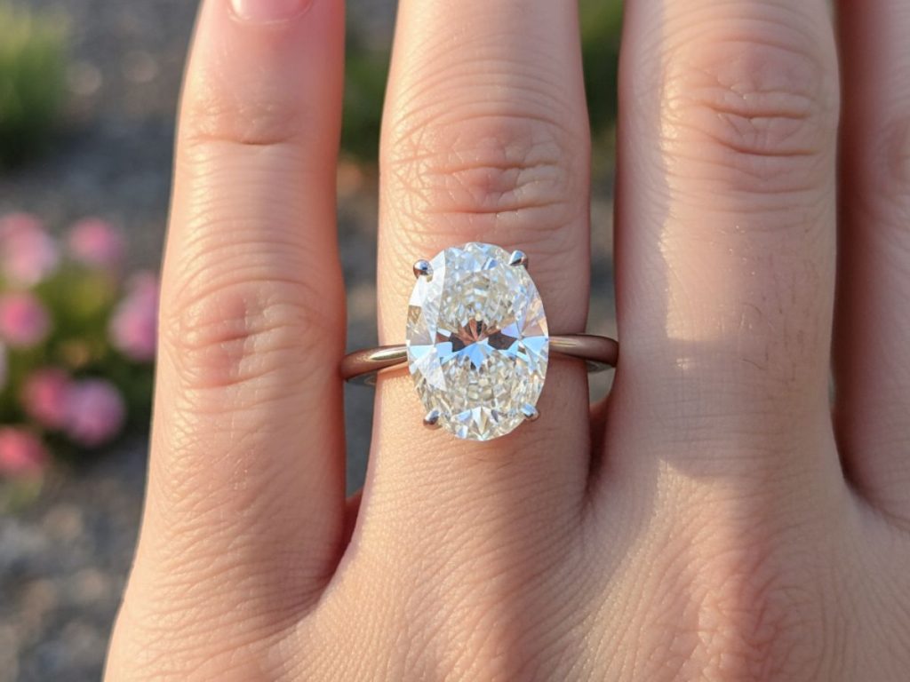 Oval cut diamond solitaire on hand