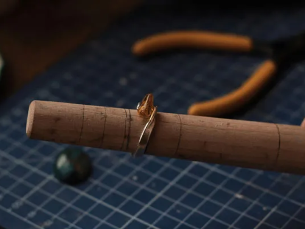 Gold engagement ring on jeweler sizing mandrel