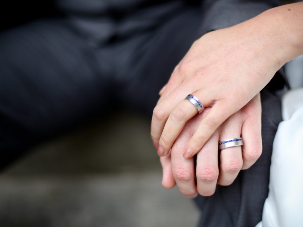 Matching wedding bands on couple holding hands