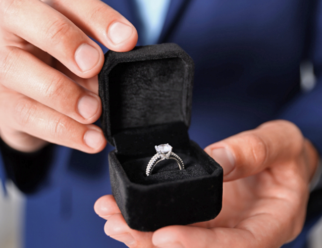 Man proposing with diamond engagement ring in black box