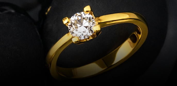 Gold ring with a diamond on a black background