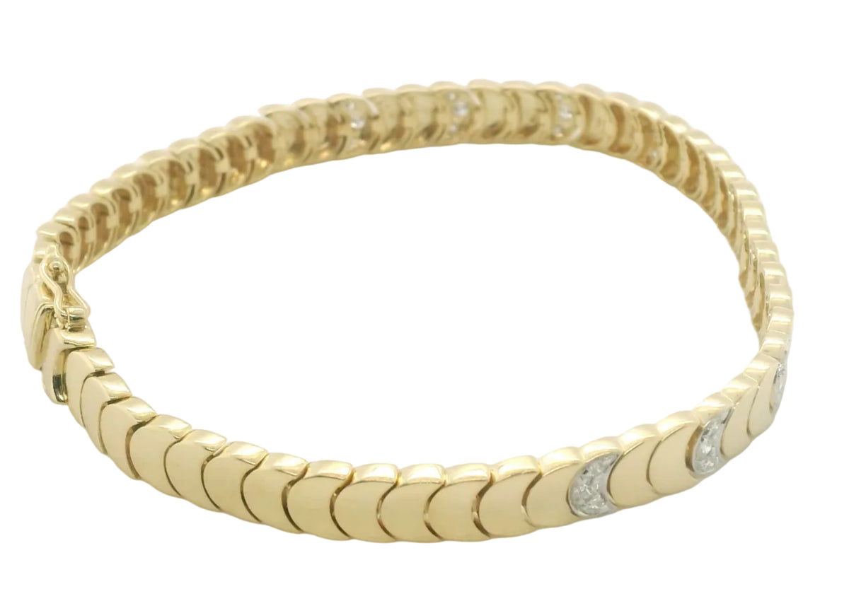 A yellow gold tennis bracelet with a textured, scalloped link design and small clear accent stones, photographed on a plain white background.