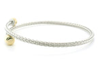 A silver braided wire bangle bracelet with a small gold ball accent, shown on a plain white background.