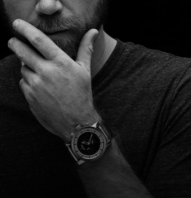 Man wearing a watch with a dark background
