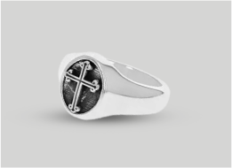 Silver ring with a black stone and cross design on a gray background