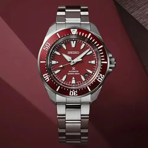 Seiko Prospex Automatic Diver with a bold red bezel and stainless steel band.